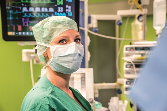 Eine medizinische Fachkraft mit Maske vor einem Herzmonitor im Operationssaal, Abteilung Anästhesiologie und Intensivmedizin, Albertinen Krankenhaus, Hamburg-Schnelsen Eine medizinische Fachkraft mit Maske vor einem Herzmonitor im Operationssaal, Abteilung Anästhesiologie und Intensivmedizin, Albertinen Krankenhaus, Hamburg-Schnelsen