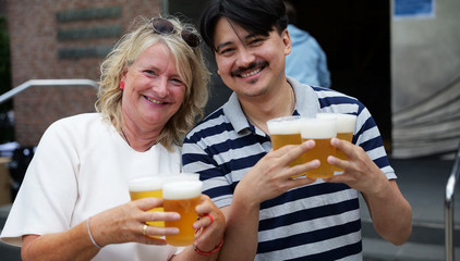Eine Mitarbeiterin und ein Mitarbeiter halten mehrere Bierbecher in die Kamera beim Albertinen-Sommerfest für die Mitarbeitenden aus den unterschiedlichen Einrichtungen der Immanuel Albertinen Diakonie am Standort Schnelsen auf dem Platz vor der Kirche am Albertinen Krankenhaus. Eine Mitarbeiterin und ein Mitarbeiter halten mehrere Bierbecher in die Kamera beim Albertinen-Sommerfest für die Mitarbeitenden aus den unterschiedlichen Einrichtungen der Immanuel Albertinen Diakonie am Standort Schnelsen auf dem Platz vor der Kirche am Albertinen Krankenhaus.